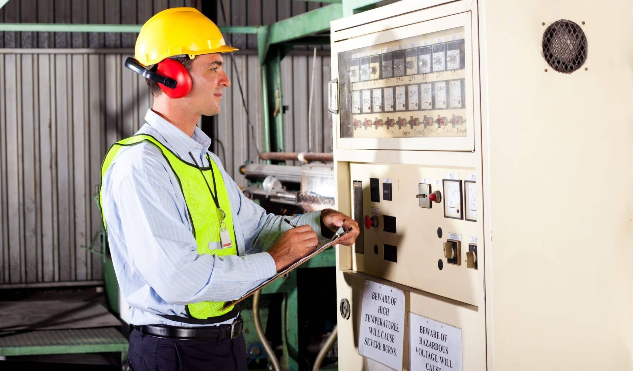 technik przemysłowy zapisujący wartości ustawienia temperatury maszyny